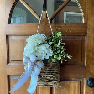 Detail of white hydrangea floral door basket with rustic rattan and large ribbon bow