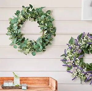 Detail of artificial eucalyptus and lavender wreaths on a white rustic wooden wall background