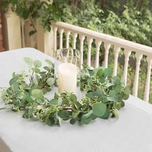 Close-up of artificial eucalyptus leaf wreath with a candle centerpiece for table decor