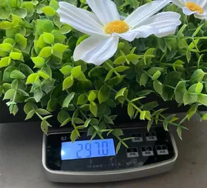 Digital scale showing the 297.0g weight of white daisy artificial flower wreath
