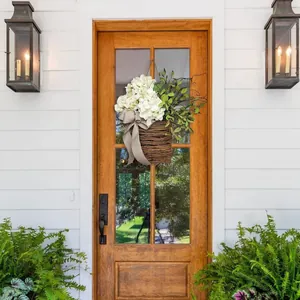 Outdoor spring hydrangea flower basket wreath with white flowers and a polka dot bow on a door