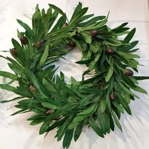 Detailed view of the artificial olive branch wreath with green leaves and dark fruits
