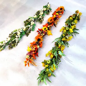 Detail of faux maple leaves, white pumpkins and berry garlands for festive table decor