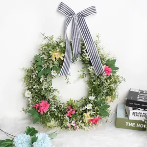 Spring daisy wreath with green leaves and striped ribbon for front door decoration