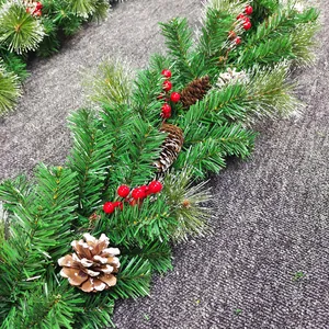 Macro detail of 2.7m Christmas garland with pine cones, red berries and snow-tipped needles