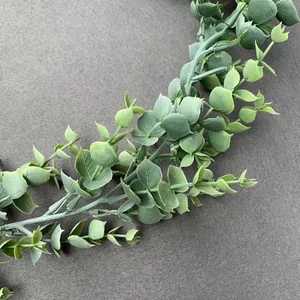 Close-up of grey-green faux eucalyptus leaves with natural matte texture on dark background