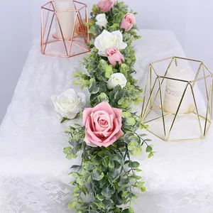 Detalle de rosas de seda rosa y blanca con hojas de eucalipto sobre encaje
