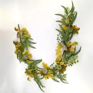 Artificial fall garland with maple leaves, mini pumpkins and berries on white background