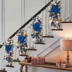 Blue and silver Christmas garland with LED lights on stairs featuring bows and pinecones