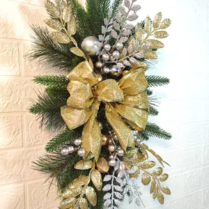 Close-up of Christmas stair swag featuring golden bows and glittery decorative leaves
