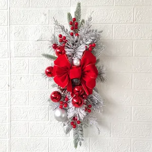 Close-up of Christmas teardrop swag with large red bow and decorative red silver ornaments