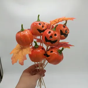 Close-up of Halloween pumpkin picks with Jack-o'-lantern faces and faux maple leaves