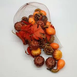 Detail of harvest festival set with pumpkins, pinecones, and maple leaves in a mesh bag