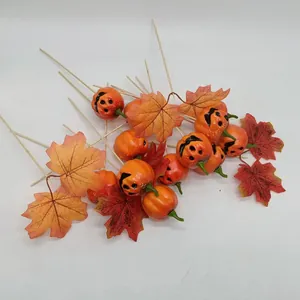 Close-up of Halloween pumpkin picks and maple leaf decorations on wooden sticks