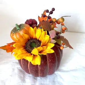 Detailaufnahme von Herbst-Deko mit Sonnenblume, bordeauxrotem Kürbis und Ahornblatt