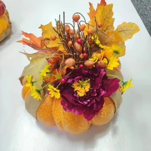 Detail von Ernte-Kürbis Gesteck mit Herbstlaub, Kunstblumen und Juteband Verzierungen