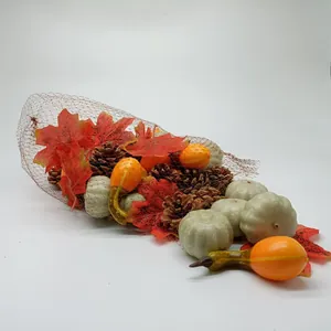 Close-up of artificial pumpkins, pine cones and maple leaves in a mesh bag for autumn decor