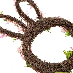 Gros plan d'une couronne de lapin de Pâques en rotin naturel avec des fleurs roses