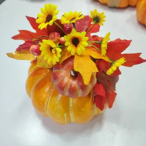 Detailansicht von Deko-Schaumkürbis mit Sonnenblumen und roten Ahornblättern