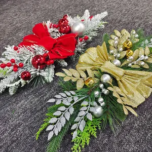 Detail of red and gold Christmas wreaths with bows and pine cones on a grey background