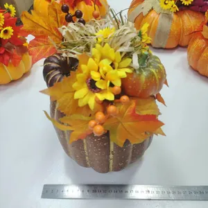 Detail von künstlichem Kürbis mit Sonnenblume, Ahornblättern und Beeren für den Herbst