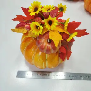Detail der Ernte-Kürbis-Deko mit Sonnenblumen und Ahornblättern auf weißem Grund