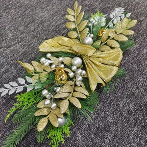 Macro detail of Christmas garland featuring golden glitter bow and metallic pine needles