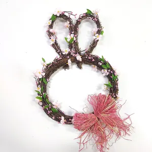 Détail d'une couronne de lapin en rotin avec fleurs de cerisier et nœud en raphia