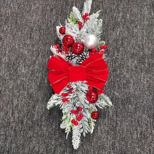 Close-up of Christmas swag with red velvet bow, flocked pine needles and red berries