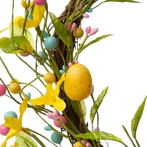 Nahaufnahme des Osterkranzes mit gelbem gesprenkeltem Ei, bunten Beeren und Frühlingsblättern
