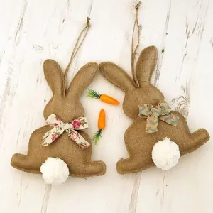 Détail de suspensions lapins de Pâques en toile de jute avec nœuds et queue en peluche