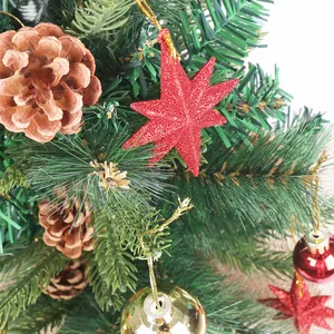 Detail of mini Christmas tree with red glitter star, pine cones and shiny gold baubles