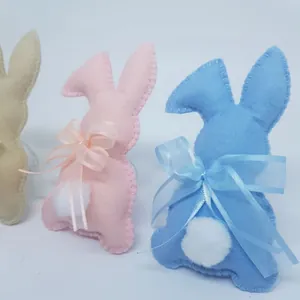 Lapins de Pâques artisanaux en feutre avec nœuds et queues en peluche en trois couleurs