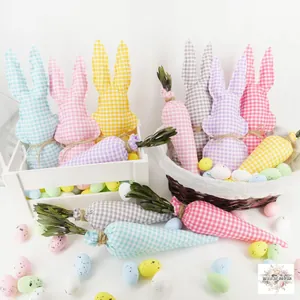 Détail de lapins de Pâques et carottes en tissu à carreaux dans un panier décoratif