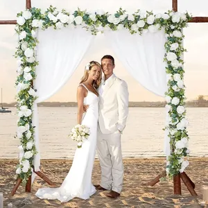 Wedding arch floral set featuring white roses and eucalyptus leaves with sheer drapes