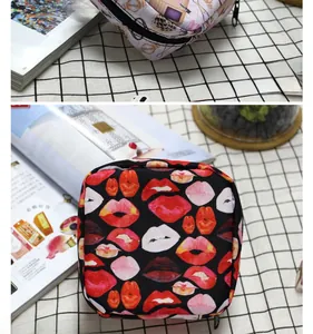 Primer plano de mini neceseres portátiles con estampados de maquillaje y labios rojos
