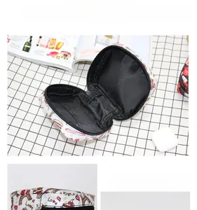 Detalle interior de un mini neceser de labios con estampado de corazones y compartimentos
