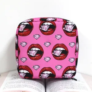 Minibolsa de cosméticos rosa con estampado de labios y diamantes sobre un libro