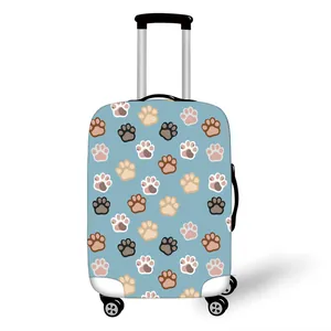 Elastic blue suitcase cover with colorful paw prints on white luggage with wheels