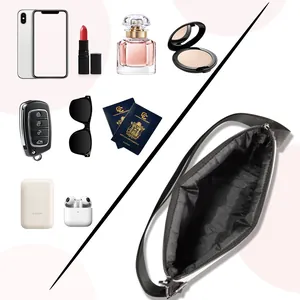 Spacious interior of black nylon shoulder bag showing storage for phone and accessories