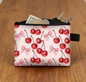Detailed view of mini cherry print coin purse with keys and money on wooden surface