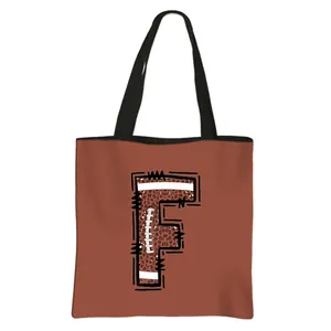 Roodbruine grote draagtas met F-letter in American football textuur en zwarte hengsels
