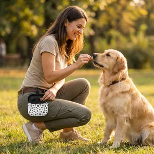 Dog training treat pouch with paw print pattern worn while feeding a Golden Retriever