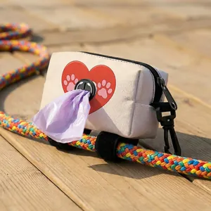 Detail of canvas dog poop bag holder with heart print and purple waste bag dispenser