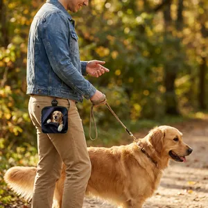 Portable dog treat pouch with golden retriever print attached to belt loop outdoors