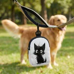 Close-up of cat-print pet treat pouch hanging on a leash in an outdoor park setting
