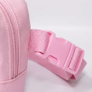 Close-up of the pink crossbody bag featuring a durable plastic buckle and nylon strap