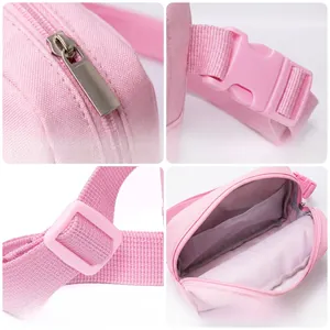 Detail view of pink canvas crossbody bag showing smooth zippers, buckle, strap, and inner lining