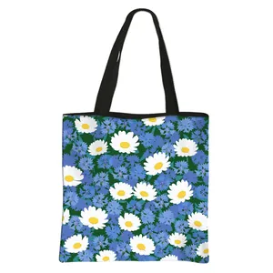 Floral canvas tote bag with white daisies and blue flowers on a dark green background