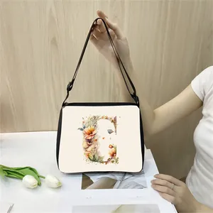 Minimalist white tote bag with floral letter C print and adjustable black shoulder strap